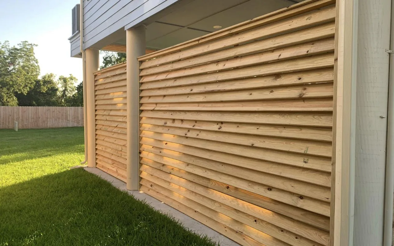 Horizontal cedar slat privacy screen fitted against the side of a house