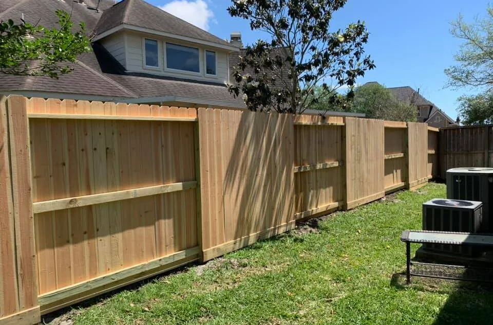 Standard Fence crew installing a wood privacy fence on a property near San Leon, Texas